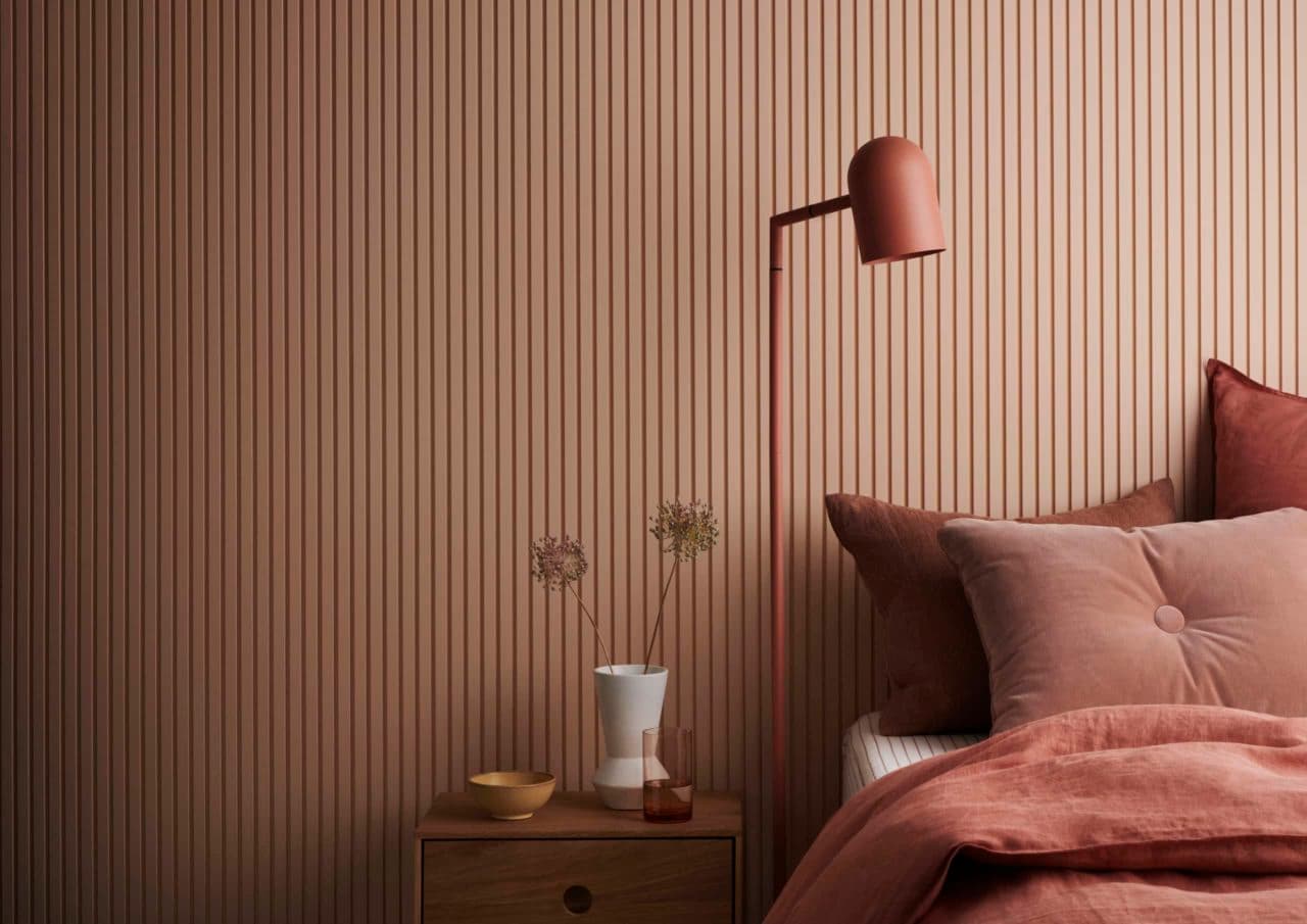 Timber batten feature wall behind a bed, painted in a warm terracotta tone